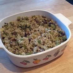 a casserole dish filled with rice and vegetables on a wooden counter top, ready to be eaten