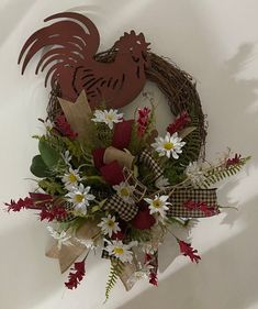 a wreath with flowers and a rooster on it