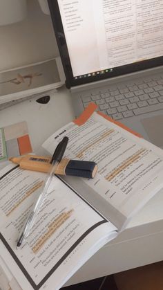 an open book with a knife on top of it next to a laptop and keyboard