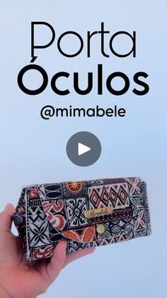 a hand holding a small wallet with the words porta oculos on it