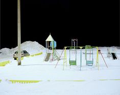 an empty playground in the snow at night