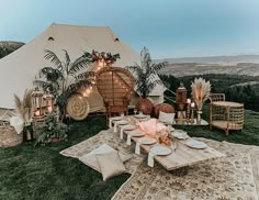 a large tent set up in the middle of a field with tables and chairs around it