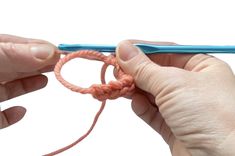 two hands holding a blue crochet hook and an orange yarn skeing