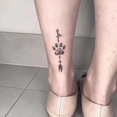 a woman's foot with a dog paw and arrow tattoo