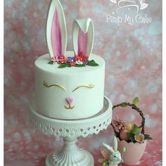 a white cake with pink bunny ears on top