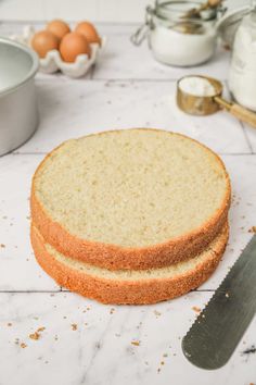 two slices of cake sitting on top of a counter next to an egg container and knife