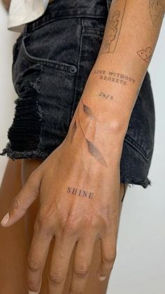 a woman's arm with tattoos on it and the words shine written in black ink