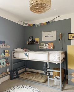 a bedroom with a bunk bed, desk and shelves on the wall next to it