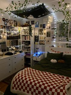 a bedroom decorated in white and red checkered bedspread with hanging plants on the ceiling