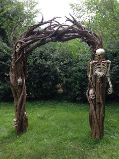 an outdoor sculpture made out of branches with skeletons on it and one skeleton in the middle