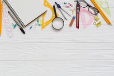 an assortment of school supplies laid out on a white surface with pencils, scissors and markers