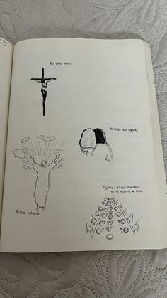 an open book with drawings of people and animals on it's pages, including a crucifix