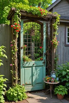 a green door with flowers growing on it and a table in the yard next to it