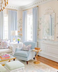 the living room is decorated in pastel blue and white with floral wallpaper on the walls