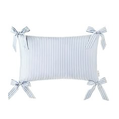 a blue and white striped pillow with bows on the front, sitting on a white background