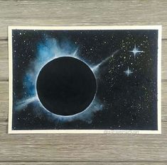 a black hole in the sky with stars around it and a wooden floor behind it