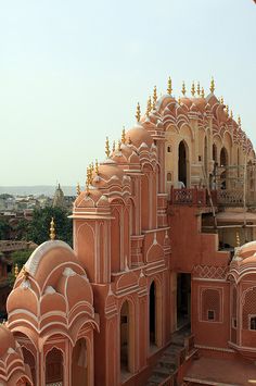 an ornate building with many windows and arches on the top floor is shown from above