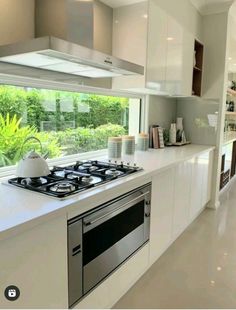 a kitchen with a stove top oven sitting next to a window and counter tops in front of it