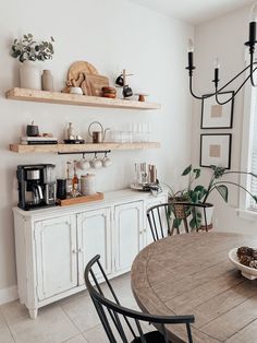 a dining room table with chairs and shelves above it