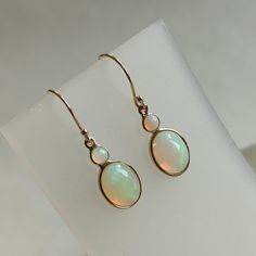 ITEM DESCRIPTION: >> The Earrings is made from Solid 14K Yellow Gold. Gemstone used is absolutely  natural and ethically sourced.  >> Natural Ethiopian Opal Earrings  in oval shape in bezel setting is studded on it with utmost precision.  >>This is a minimalist design and is absolutely hassle -free and everyday jewelry. Gem: Ethiopian Opal Gem size: 7x9 mm  oval Gem size : 3mm round Total Gem weight: 2.48 carats Gold purity: 14K (58.33% approx.) Gold weight: 0.66 grams  Gross weight : 1.16 grams Fine Jewelry Oval Earrings With High Luster, Ethiopian Opal Earrings, Bezel Set Earrings, Opal Drop Earrings, Handmade Jewelry Box, Bezel Earrings, Yellow Gold Earrings, October Birthstone, Unique Gemstones