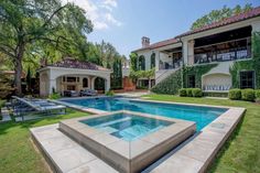 an outdoor swimming pool in front of a large house