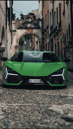 a green sports car parked in an alley way