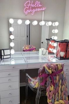 a desk with a chair, mirror and lights on it