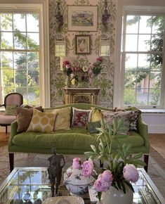 a living room filled with lots of furniture and flowers on top of a coffee table