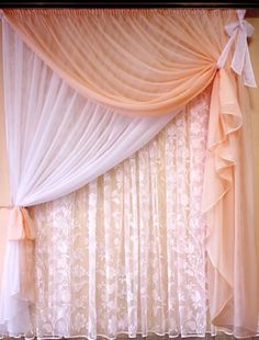 the curtains are hanging in front of the window with sheer drapes on top of them