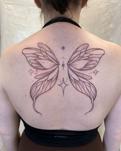 the back of a woman's shoulder with a butterfly tattoo on it