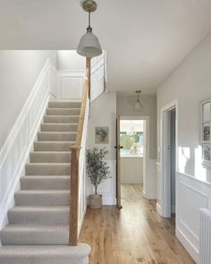 the stairs in this house are made of wood and white with light gray carpeting