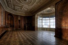 an empty room with wood paneling and large windows