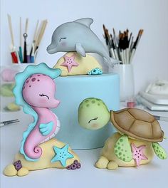 two sea animals and a turtle on top of a cake