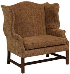 an upholstered wing chair with wooden legs