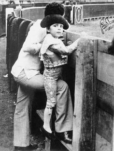 an old black and white photo of a woman holding a child