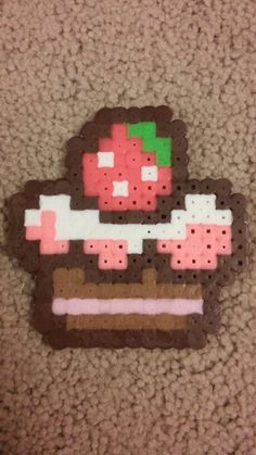 an image of a piece of cake made out of perler beads on the floor