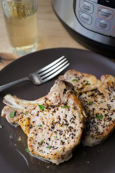 two cooked pork chops on a black plate with the title instant pot pork loin chops