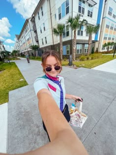 a woman is taking a selfie with her cell phone while riding a bike down the street