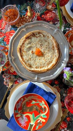 an assortment of food items on a table with plates and utensils in the background