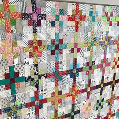 a very large quilt made with many different colors and patterns on the back of it