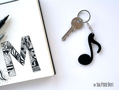 a music note keychain next to an open notebook