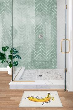 a bathroom with a shower, rug and potted plant