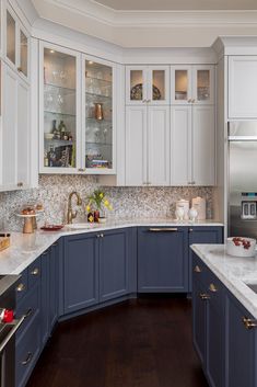 a kitchen with blue cabinets and white counter tops, along with wooden flooring in the middle