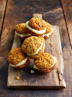 carrot muffins with cream cheese frosting on a wooden cutting board, ready to be eaten