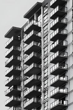 an apartment building with balconies on the top and bottom floors, in black and white