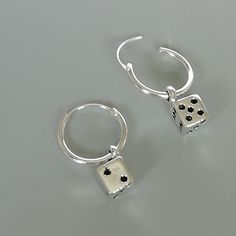 A PAIR of sterling silver hoops. Comes with a detachable dice charm. The charm is multipurpose and can be used with a neck or bracelet chain too. Dimension: Hoop- 12x1 mm Charm: 5 x8 mm Drop length- 19 mm These earrings are made of real 925 hypoallergenic sterling silver. Please let me know if you want the piece in a gift box. I can write out a message from you to the receiver if needed. Please be free to contact me at... bhavnakwintra1956@gmail.com More hoops: https://www.etsy.com/your/shops/Th Silver Dangling Charms Earrings As Gift, Nickel-free Silver Dangle Huggie Earrings, Silver Earrings With Dangling Charms For Gifting, Silver Nickel-free Dangle Huggie Earrings, Silver Earrings With Dangling Charms As Gift, Silver Dangle Huggie Earrings Nickel-free, Silver Huggie Earrings With Charms, Charm Small Hoop Metal Earrings, Silver Charm Hoop Earrings