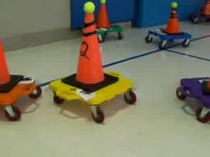 children's toys are lined up on the floor in an indoor play area with traffic cones