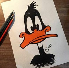 a drawing of a cartoon ducky with an orange beak and black head, on a piece of paper