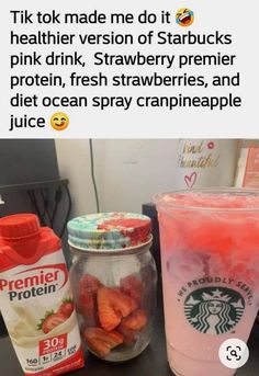 there is a jar of strawberries next to a cup of juice and a bottle of strawberry drink