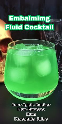 a green drink in a glass next to a skull on the table with text overlay that reads embaling fluid cocktail sour apple punch blue curreo rum pineapple